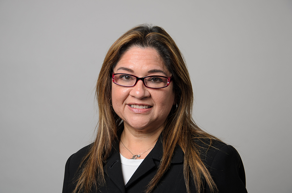 Portrait of Marta Calderon wearing a black blazer and white shirt.