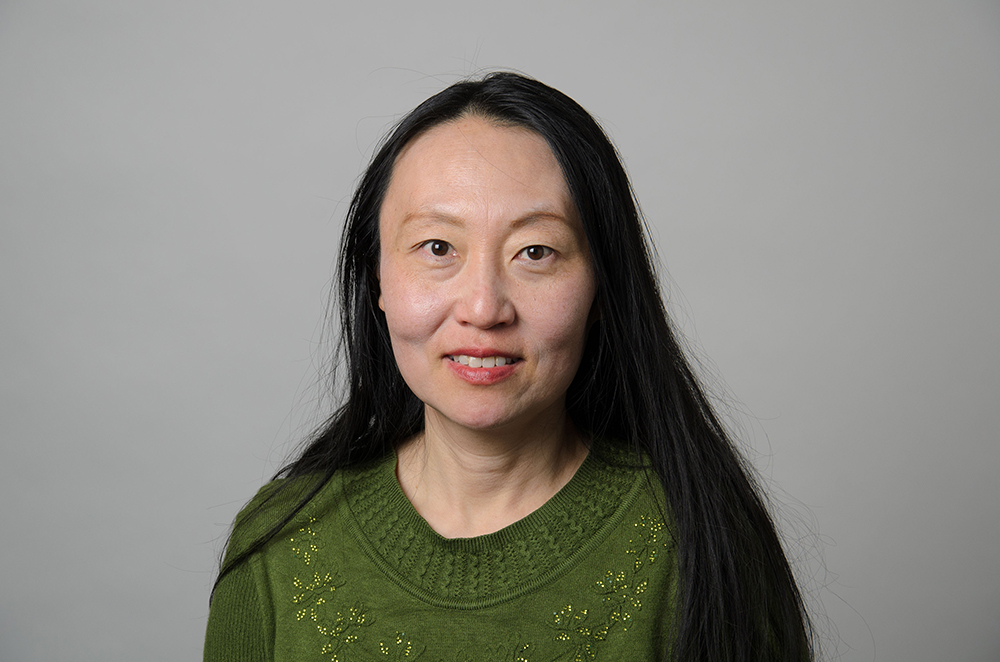 Portrait of Lulu Dong wearing a green sweater.