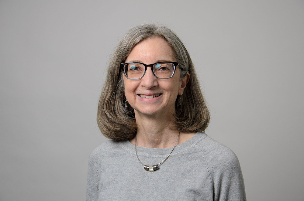 Portrait of Ingrid Semaan wearing glasses and a gray sweater.