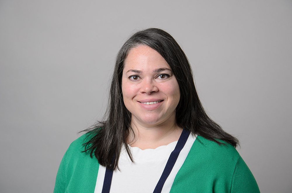 Portrait of Lynsi Vaitukaitis wearing a green sweater and white shirt.
